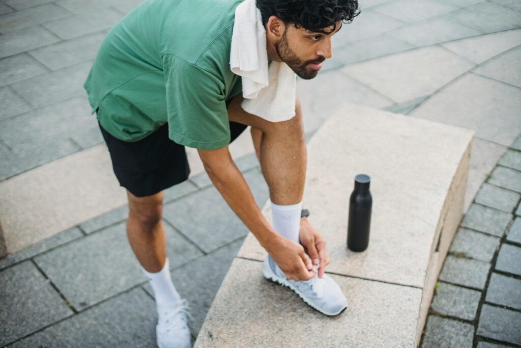 Athlete preparing for a run by tying sneakers outdoors. Perfect for fitness and lifestyle content.